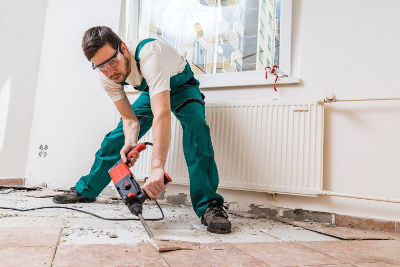 Personne qui rénove un vieux carrelage dans sa salle de bain